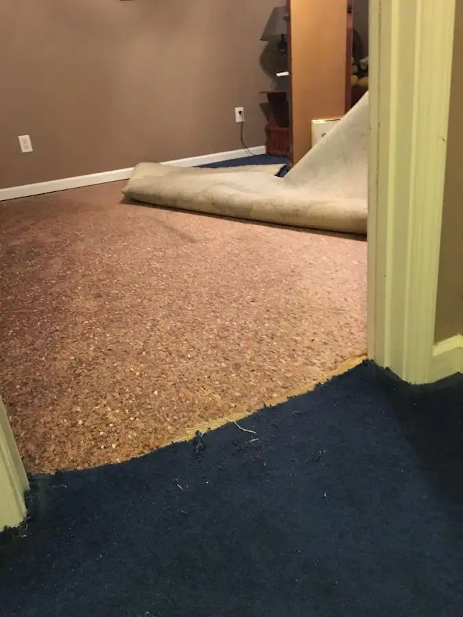 Carpet pad removal revealing water damage during Water Mitigation Services in Statesville